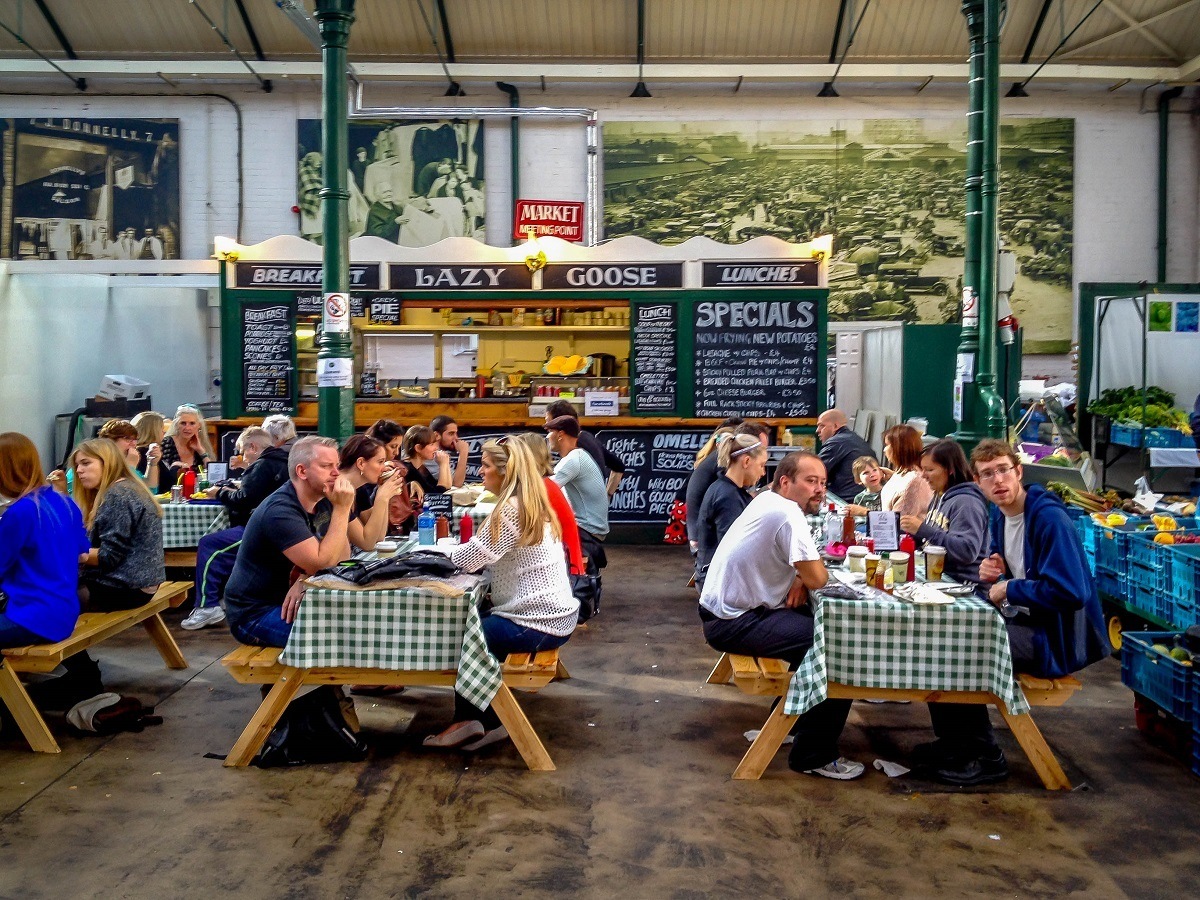 People eating at picnic tables in a market