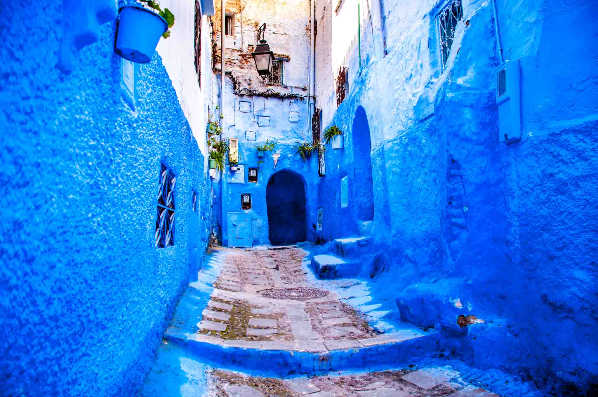 Blue alleyway with an arched door at the end