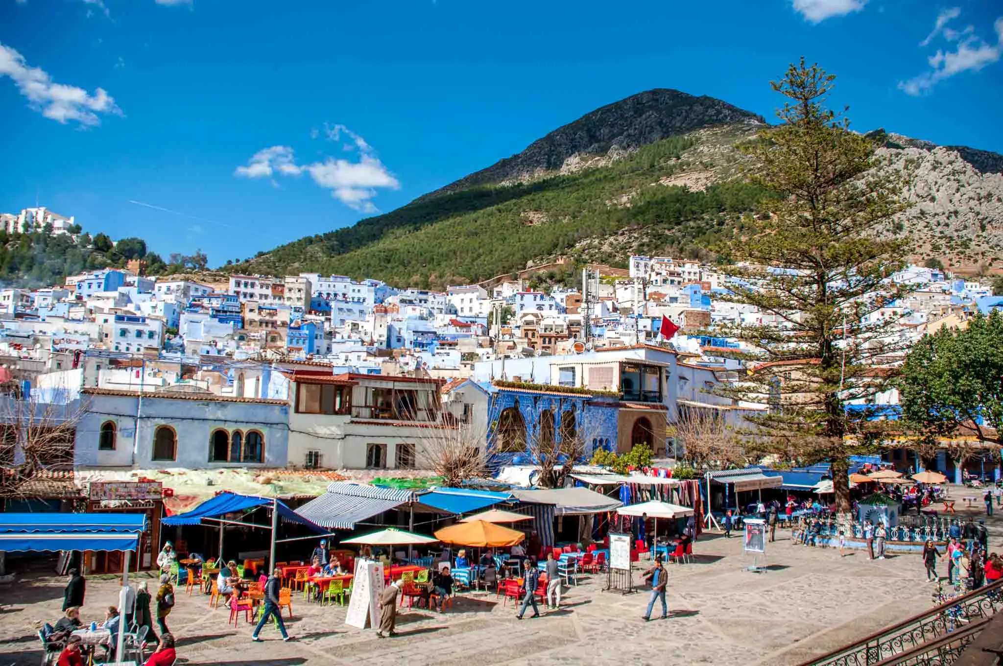 Central city square and blue buildings at the base of a mountain